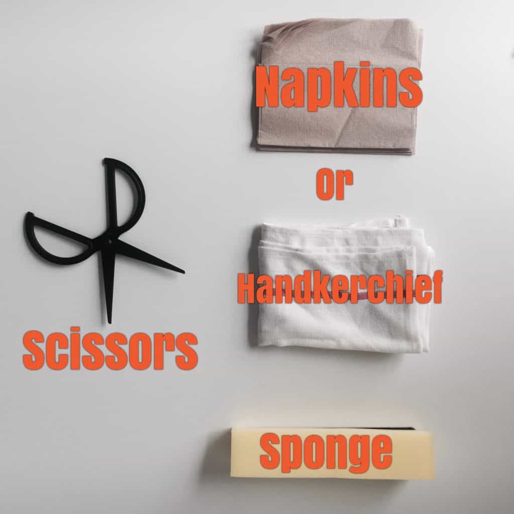 scissors, napkins, handkerchief, and sponge laid on table in bird's eye view