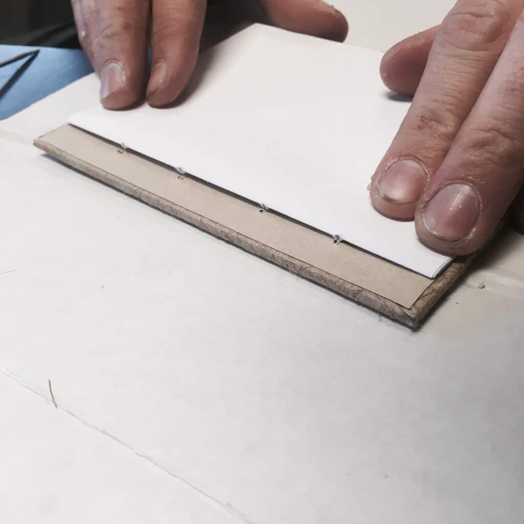 lining up paper to holes of book for binding