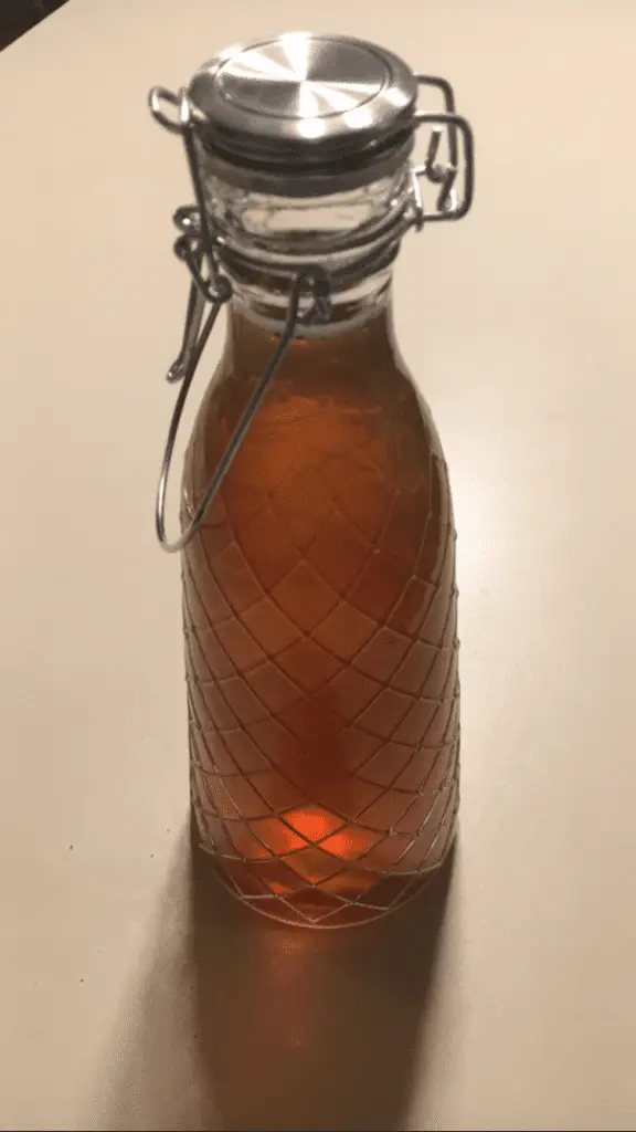 homemade kombucha in a swing top bottle, sitting on a kitchen counter