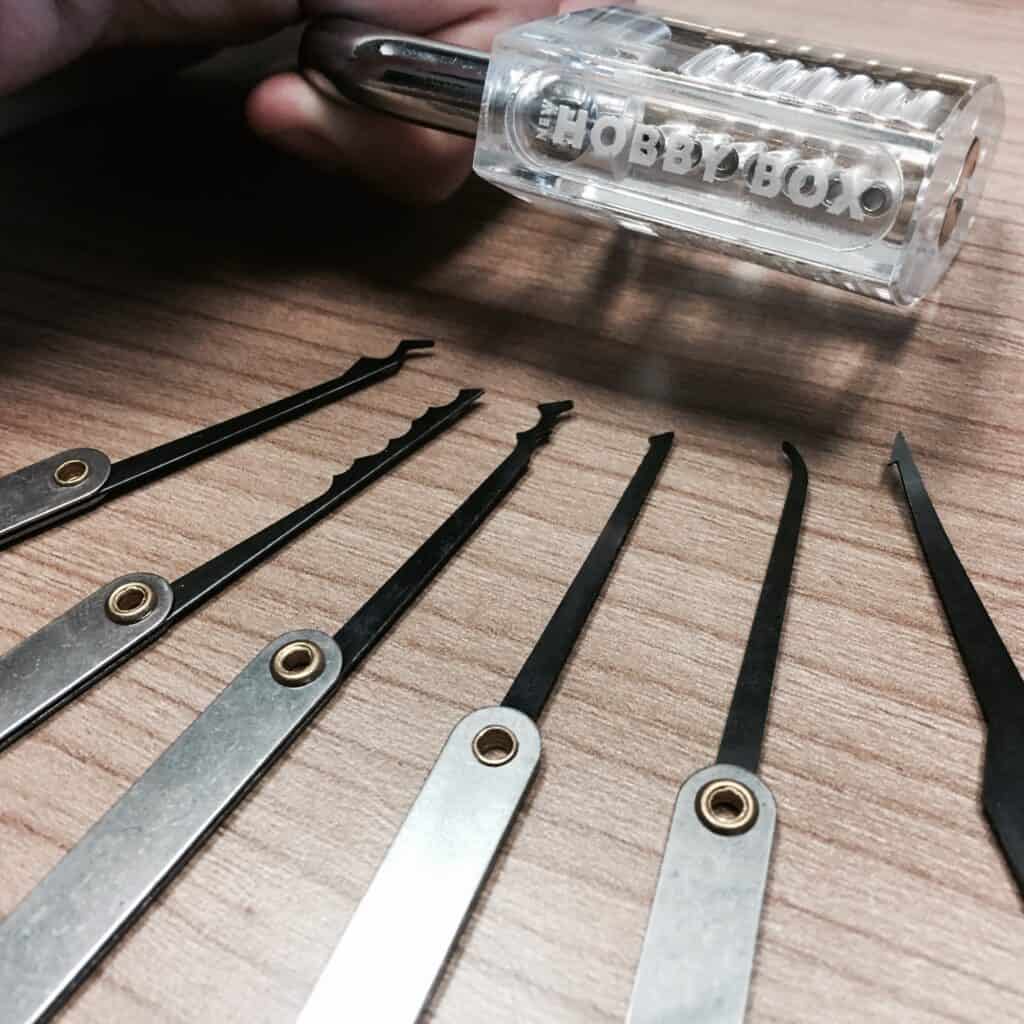 translucent padlock that says new hobby box with lock picks on table
